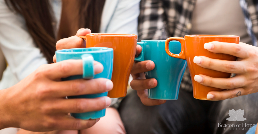 People in a circle holding teal and orange coffee cups